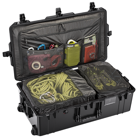 A black Pelican Air 1615 travel case open and organized with various items such as a camera, cables, and clothing.